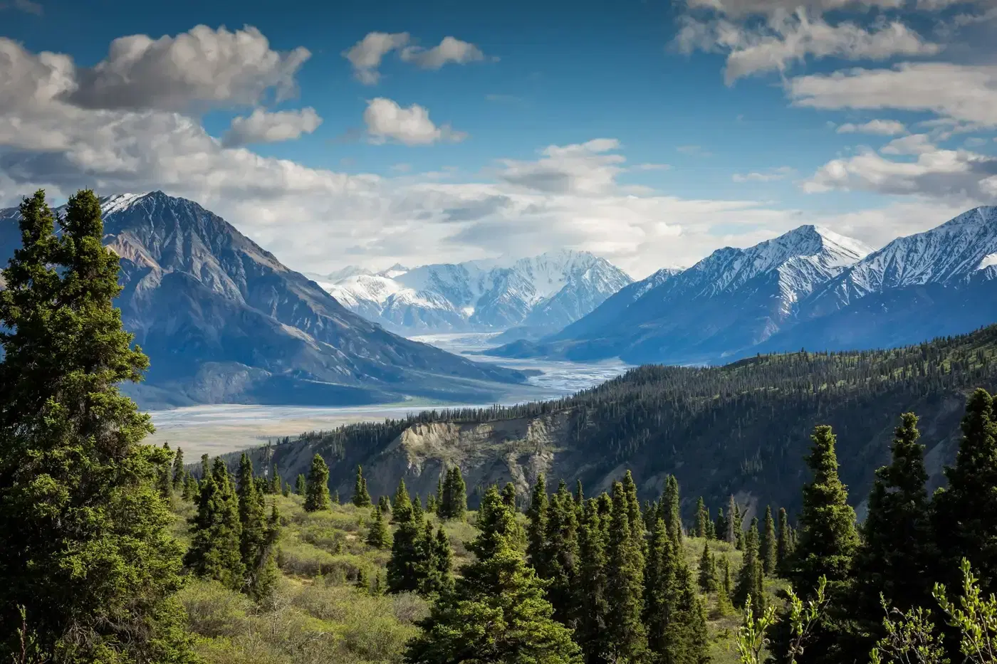 Snow-covered mountains beyond a forested valley Snow-covered mountains beyond a forested valley
